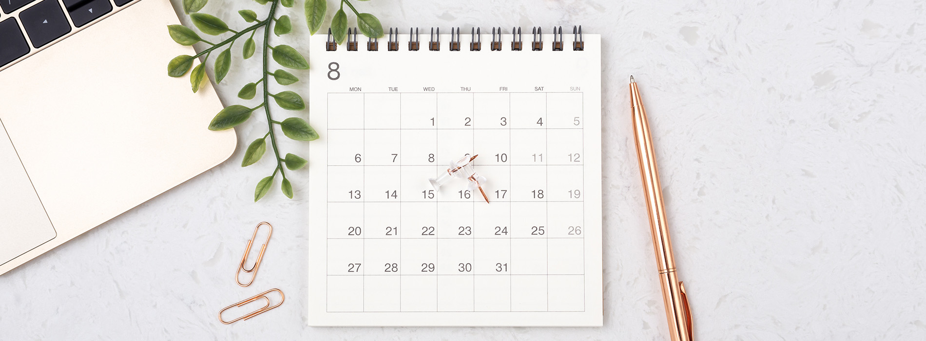 The image features a calendar with a pen and a notebook on a desk, suggesting an office setting with a focus on organization and planning.