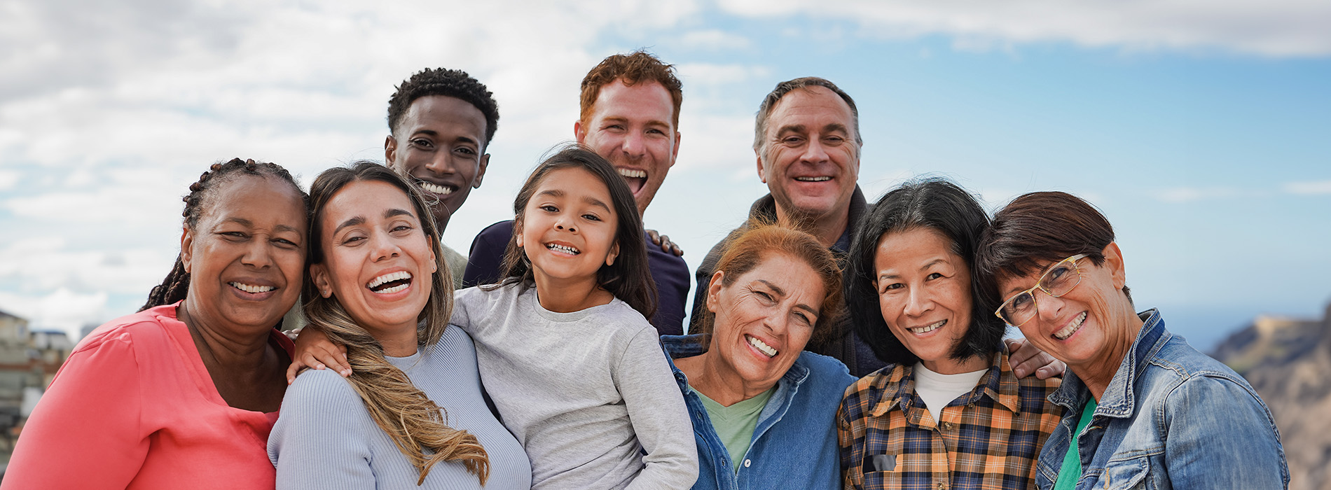 A group of people posing together outdoors with mountains in the background.