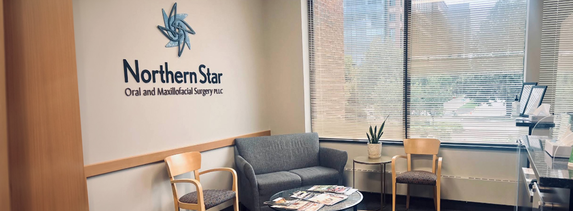 The image shows an interior office space with a view of the outside through large windows, featuring a logo on the wall and a sign indicating Northern Star Dental.